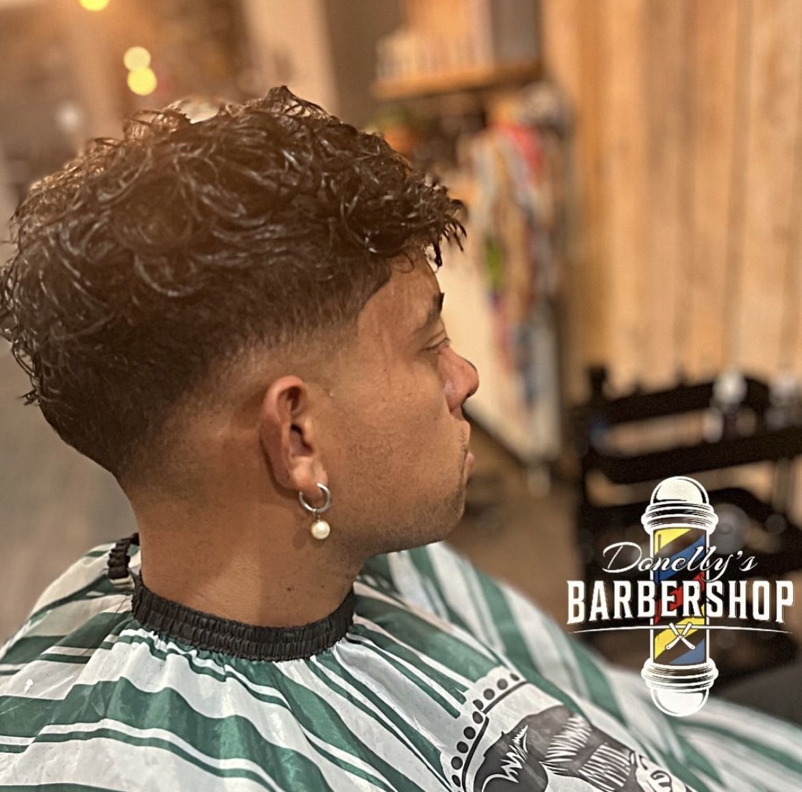 Krullen bovenop met een strakke taper fade